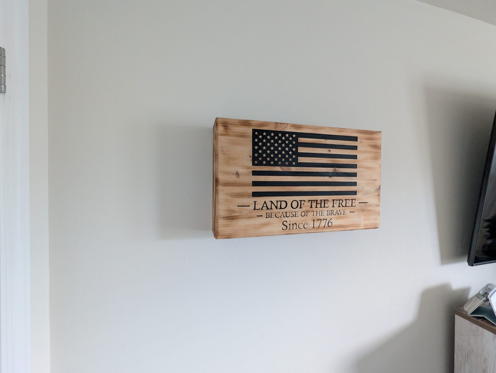 Cabinet detail — torched pine grain and hand-carved lettering
