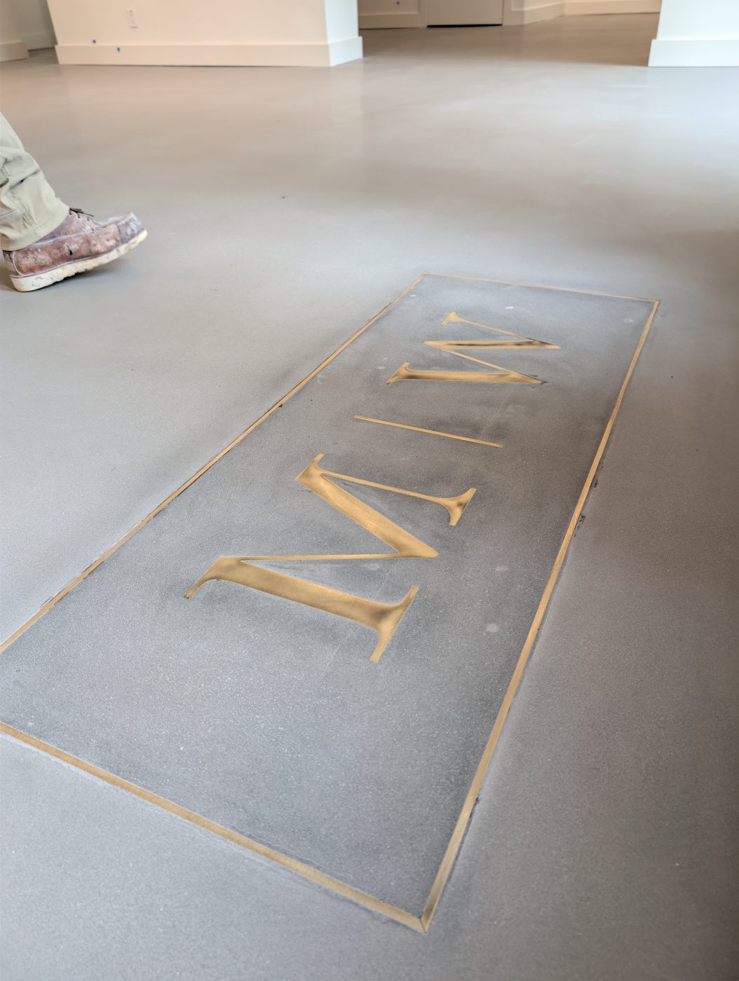 Brass monogram inlaid in polished concrete